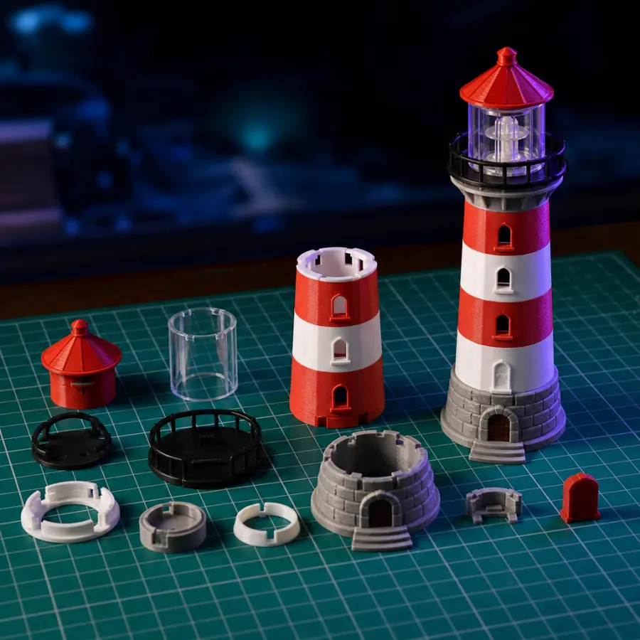 Phare imprimé en 3D découpé en pièces à emboîter, à côté du modèle assemblé